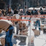 Les parelles de joves paletes, alçant les columnes a la cèntrica plaça Sant Domènec de Manresa. | Foto: Carla Baraldés/Gremi de Constructors de Manresa i Comarques.